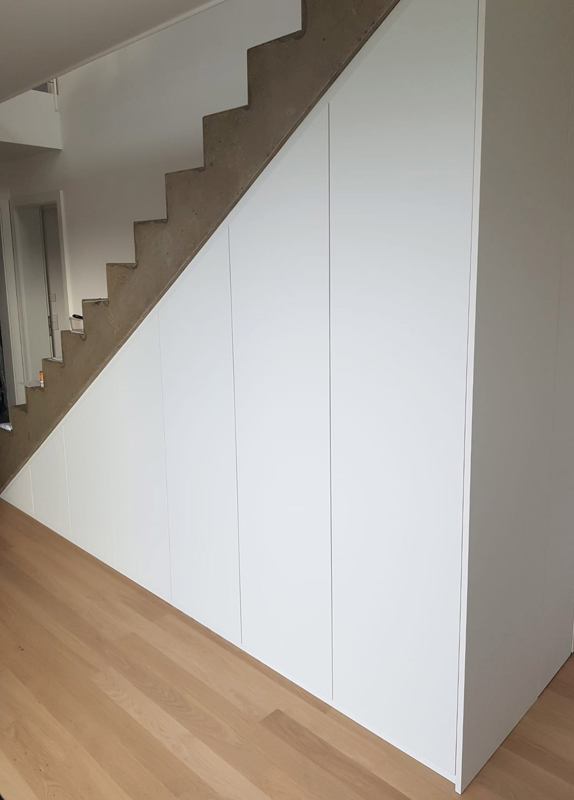 Einbauschrank unter Treppe eingepasst als Raumtrenner