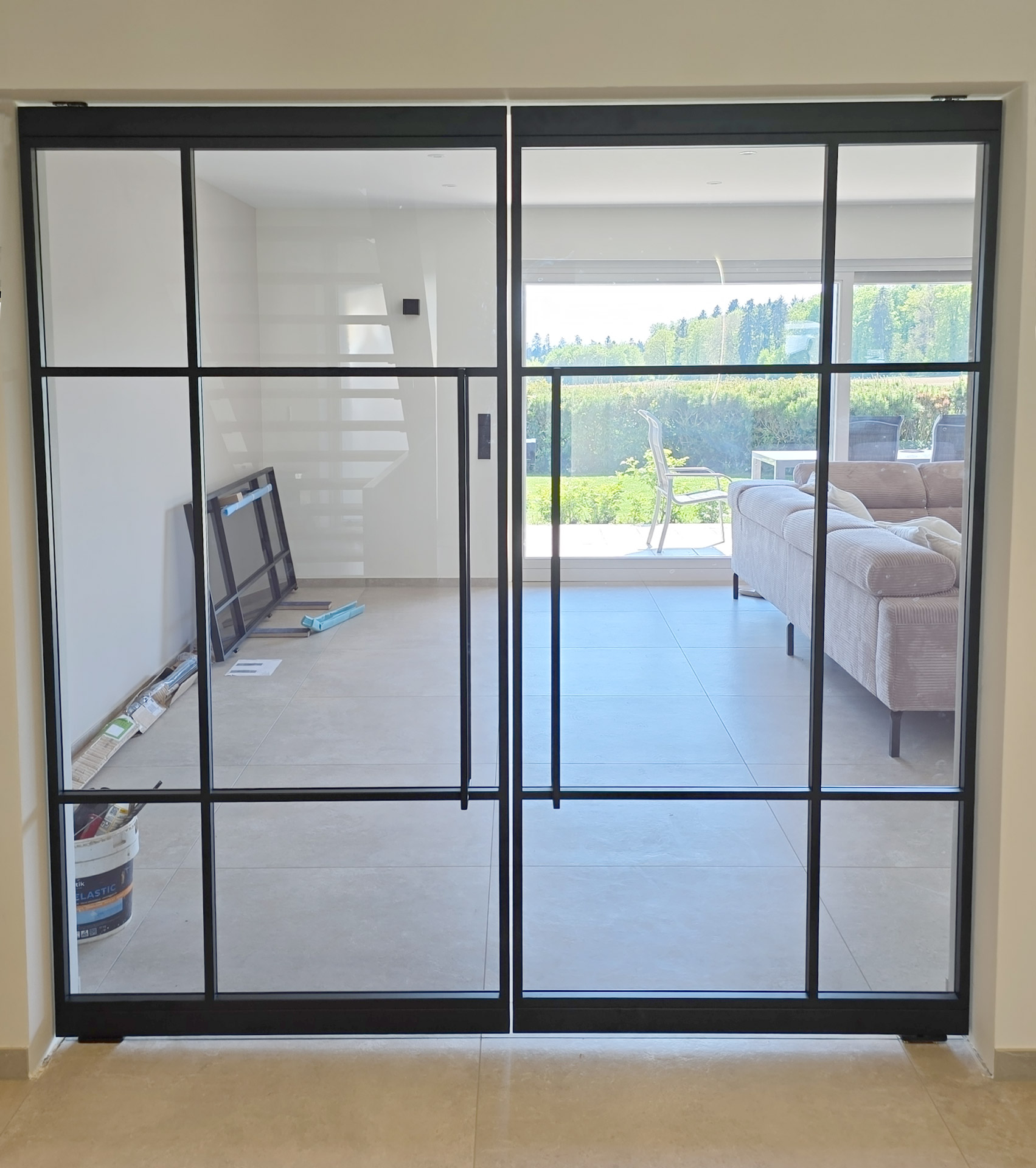 Doppelschwingtür aus Glas mit schwarzem Metallrahmen