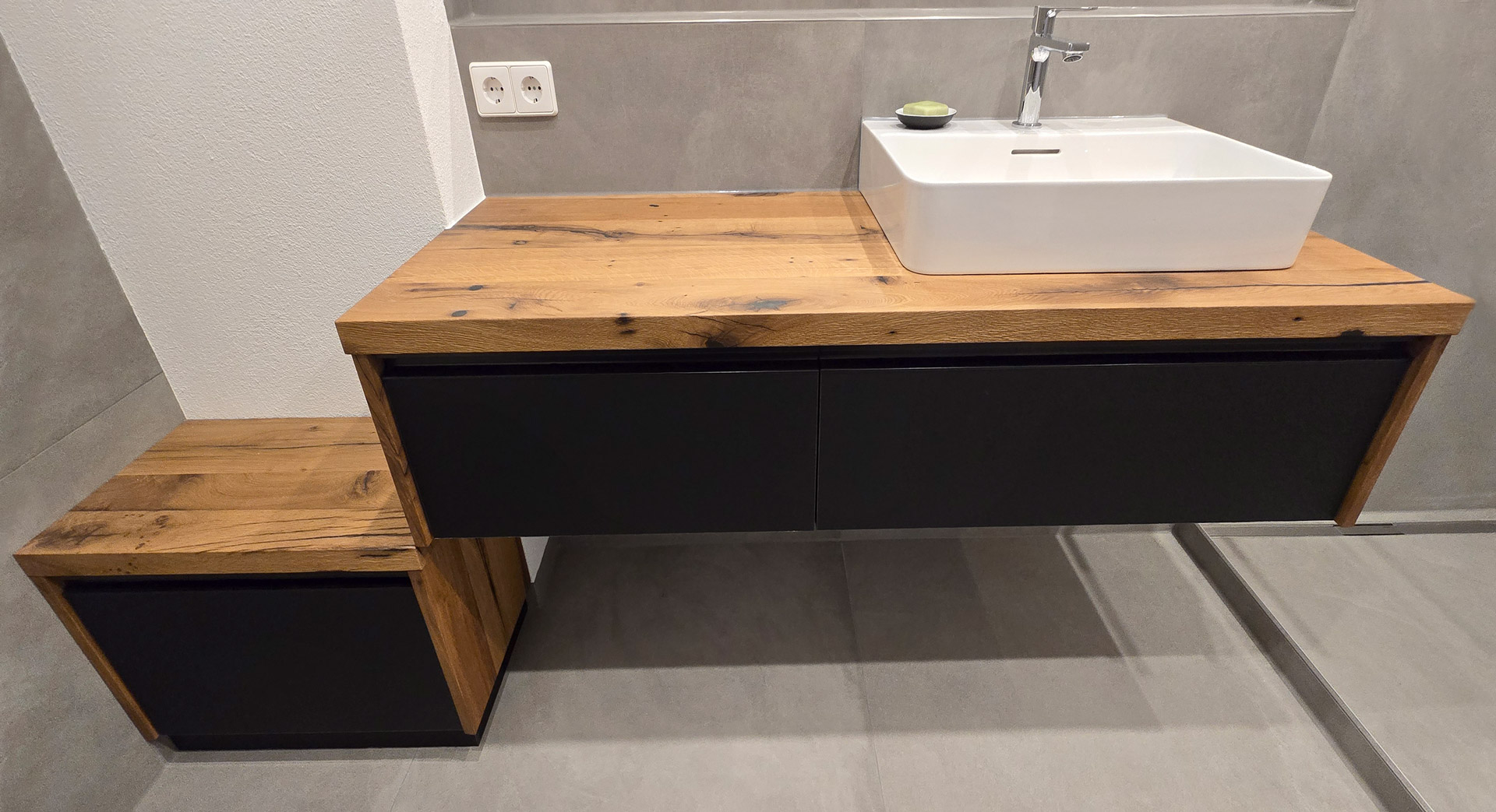 Waschbeckenunterschrank aus Risseiche mit schwarzen Fronten